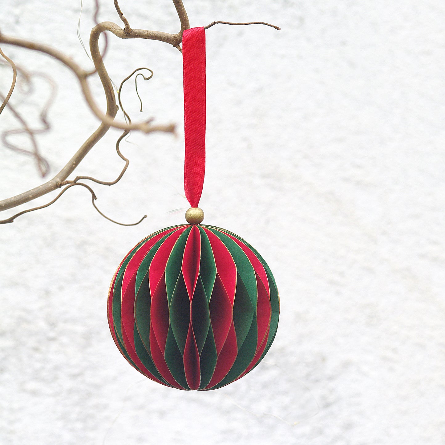glob de craciun handmade, din hartie, forma sferica, rosu cu verde, design fagure, agatat pe o crenguta. Ornament brad mare.